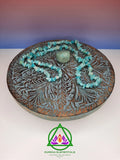 Amazonite Necklace and Crystal resting on a wooden stand with a red and blue ombre backdrop.