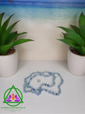 Aquamarine Necklace and Blue Topaz Crystal resting between two planters with a beach background. 